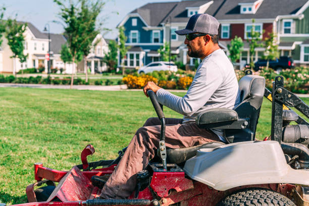 Professional landscaper on riding mower in neighborhood