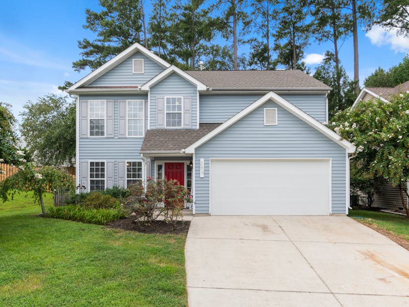House with fresh mulch beds trimmed shrubs and green lawn